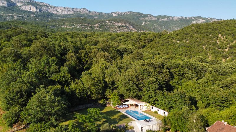 Bazen kampa okružen gustom šumom, sa planinskim vijencem u pozadini